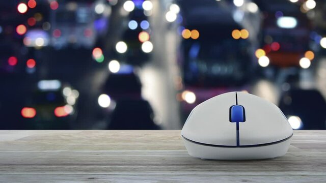 Download flat icon with wireless computer mouse on wooden table over blur colourful night light traffic jam road with cars in city, Technology internet online concept