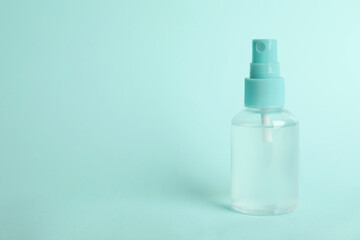 Antiseptic spray on light blue background. Space for text