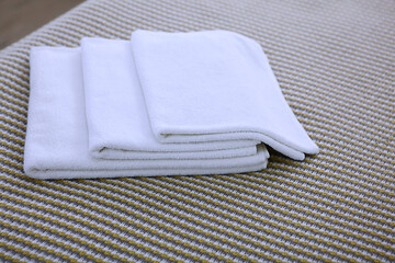 Three Terry-cloth white towels lie in a pile. The view from the top. Copy of the space. The concept of the hotel business.