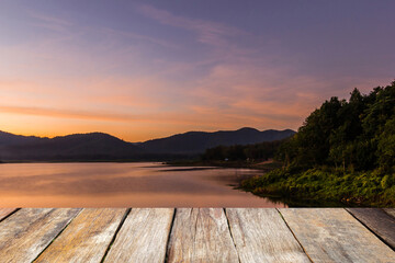 Fototapeta na wymiar Wood table top on blurred beautiful sunset at the lake and mountain. Beauty natural background - can be used for product display montage