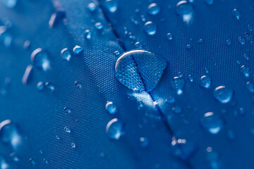 Rain droplets on a blue waterproof fabric  background