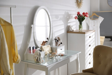 Stylish room interior with elegant dressing table and comfortable chair