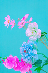 Fototapeta na wymiar Plastik flowers aesthetic on blue background. Minimal