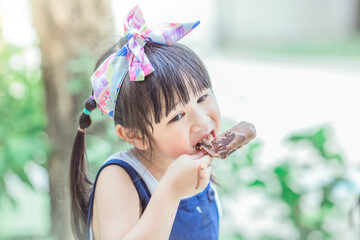 Close up background view Of ASEAN girls eating delicious ice cream, with chocolate flowing on clothes, the concept of self-learning