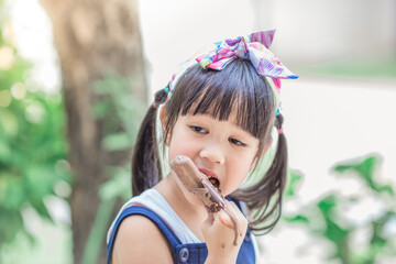 Close up background view Of ASEAN girls eating delicious ice cream, with chocolate flowing on clothes, the concept of self-learning