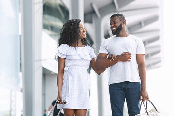 Romantic Travel. Happy Black Couple Walking Near Airport Building With Luggage