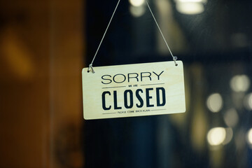 sorry we are closed sign hanging outside a restaurant, store, office or other. Closed sign in a...