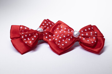 two red polka dot bow hairpins with a heart in the middle. accessories concept. Isolated, copy space. Macro Shot. High quality photo