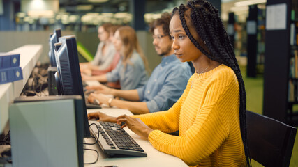 University Library: Gifted Beautiful Black Girl using Computer for Class Assignment. Diverse Multi-Ethnic Group of Students Learning, Studying for Exams, Work on Computers, Talk in College Study Room
