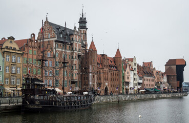 Fototapeta na wymiar Barco en Gdansk, Polonia. Fotografía urbana nocturna de paisaje urbano. Río y edificios.