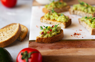 Guacamole toasts on a wooden board. Healthy and tasty snack