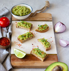 Guacamole toasts. Spread over a crispy bread slices and ingredients. Mexican cuisine