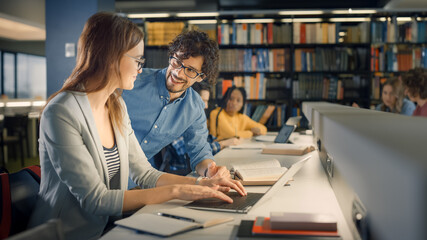 Obraz premium University Library: Talented Caucasian Girl uses Laptop, Smart Helpful Classmate Explains and Advices Her with Class Assignment. Happy Diverse Students Talking, Learning, Studying Together for Exams