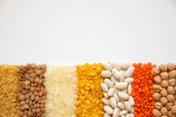 Aligned some legumes, red lentil, dry chickpeas, beans, bulgur wheat, rice and yellow lentils.