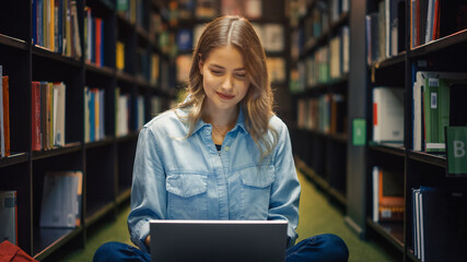 University Library Study: Smart Beautiful Caucasian Girl Sitting Cross-Legged On Floor, Uses Laptop, Writes Notes for Paper, Essay, Study for Class Assignment. Students Learning, Studying for Exams.