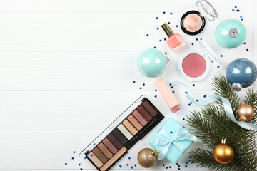 Beautiful composition with a Christmas decor and makeup cosmetics on a light background top view.

