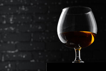 Whisky glass against dark black grunge wall