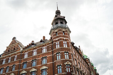 Obraz premium Arquitectura en Copenhague, Dinamarca. Edificio de ladrillos rojos en un cielo con nubes.