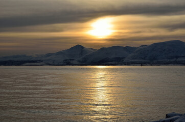 beautiful sunset over snowy mountain and fjord