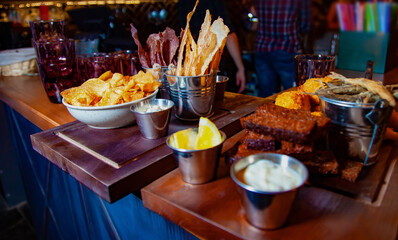 Snack to beer with different sauces on a wooden plate