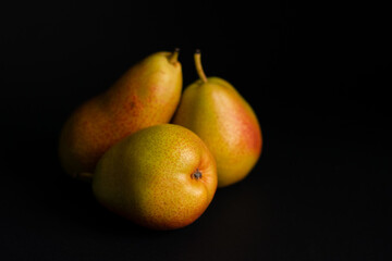 Three pears over a black background