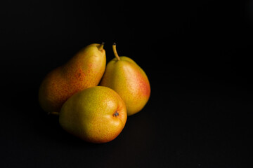 Three pears over a black background