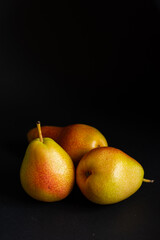 Three pears over a black background