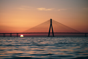 An evening by the beach: Bandra Worli Sea Link, Mumbai View during Sunset, Silhouette of the bridge with Sun going down