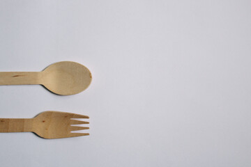 Flat-lay concept of a bamboo fork and spoon on a white background, plastic-free concept, environmentally friendly concept