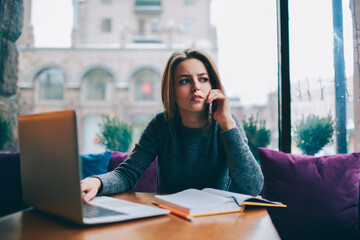Obraz premium Smiling attractive student spending free time in coffee shop interior on exam preparation