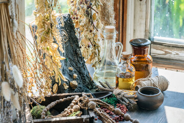 Magic potion bottles, spell book and dried plants on the witch doctor table. Witchcraft.