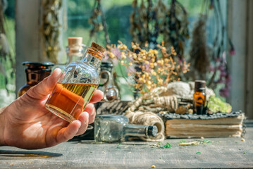 Witch doctor is preparing a magic potion by his magic desk background.