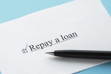 Obraz premium a piece of paper with the inscription repay a loan from to do list with a tick 