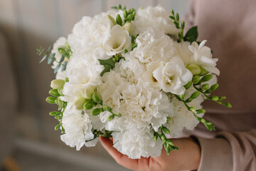 Beautiful girl’s bouquet in the hands of carnations and other flowers
