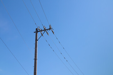Steel electric tower and cables with blue sky background in JAPAN.
