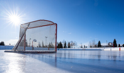 Hockey net on clear sunny winter day with sunburst on fresh ice