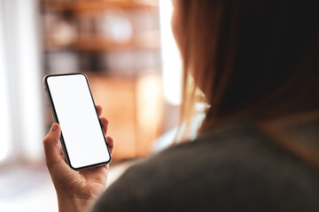 Woman using smartphone frameless mockup blank screen in home interior