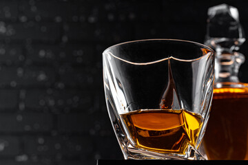 Whisky glass against dark black grunge wall