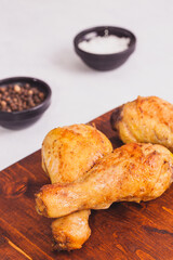 Fried crispy chicken legs, Thigh wooden cutting board with spice on table