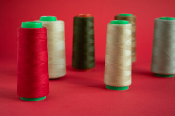 Bobbins on red background. Sew and tailoring concept, sewing tools, needlework.