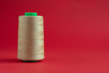 Bobbins on red background. Sew and tailoring concept, sewing tools, needlework.