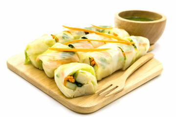 Stuffed steam chinese cabbage rolls on cutting board with tofu, mixed vegetable and green spicy sauce isolated on white background