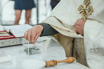 Priest hand that holds the Bible and Cross