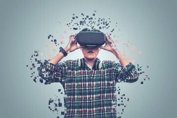  Asian man wearing glasses of virtual reality dissolving into pixels is touching on gray background Future Technology Concept