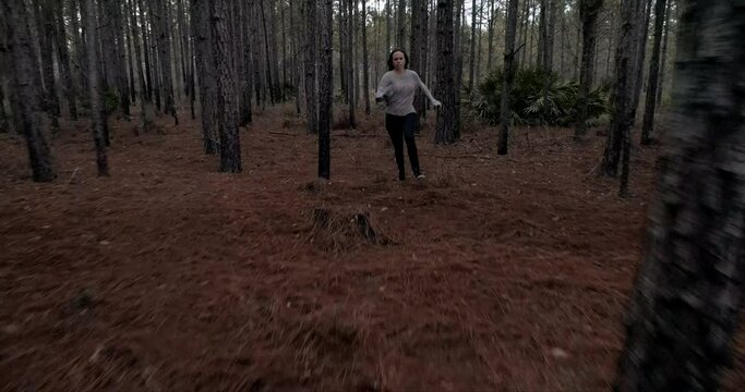 Woman running scared in dark forest, being chased
