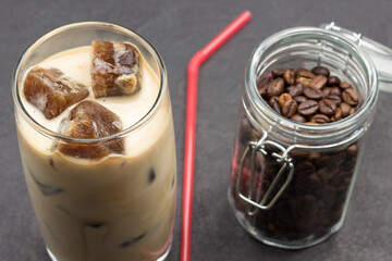 Coffee ice cubes in glass with milk. Coffee beans in glass jars.
