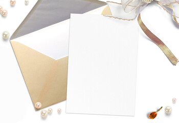 Blank invitation card on craft envelope and wedding decoration environment objects isolated on white. Wedding workspace close up view mockup scene.