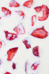 filled frame background wallpaper shot of strawberries on the surface of a milky white vanilla cheese cake cream liquid