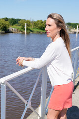 pretty young woman blonde on water side lake in summer vacation