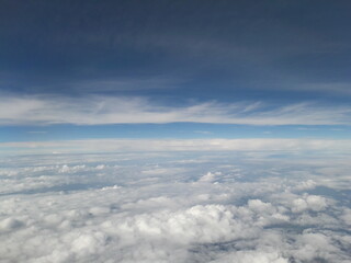 Blue sky above the clouds, lots of cumulus clouds.